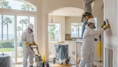 Water damage restoration team in Oceanside, CA inspecting and drying a damaged property
